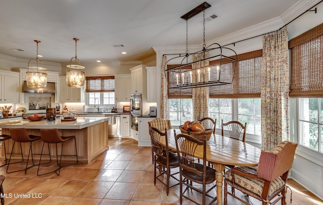 dining room with a chandelier, plenty of natural light, and ornamental molding