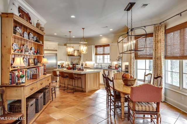 dining space featuring a notable chandelier, a wealth of natural light, crown molding, and sink