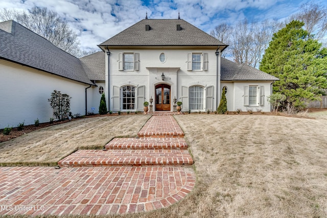 view of front of home featuring a front lawn and french doors