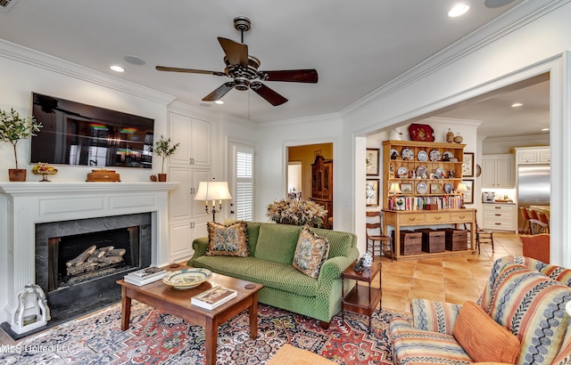 living room with ceiling fan, light tile patterned floors, a high end fireplace, and ornamental molding