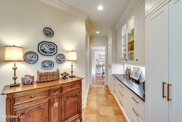 interior space featuring light tile patterned floors and crown molding