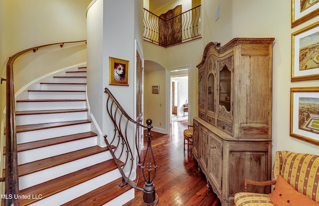 stairway featuring a high ceiling and hardwood / wood-style floors