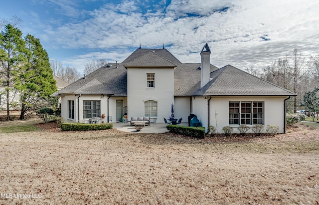 rear view of property featuring an outdoor hangout area and a patio area