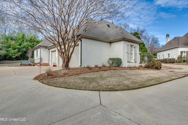 view of property exterior featuring a garage and a yard