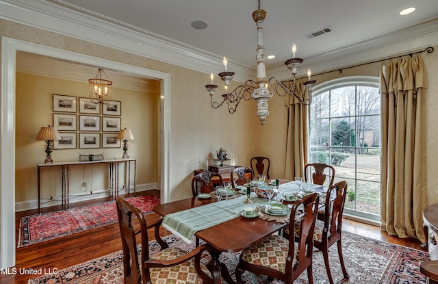 dining room with a healthy amount of sunlight, a notable chandelier, ornamental molding, and hardwood / wood-style floors