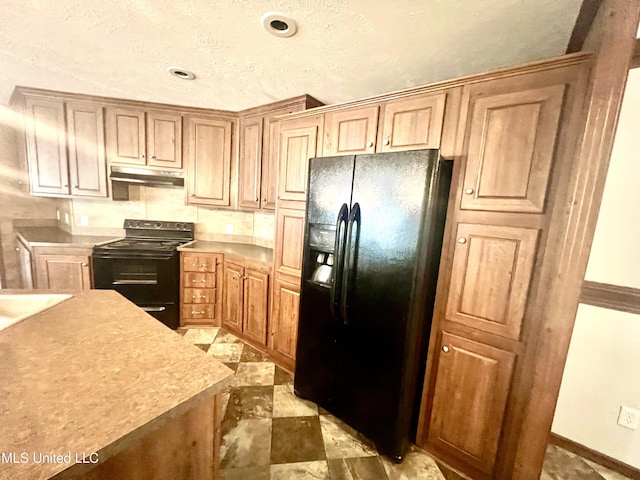 kitchen with black appliances, under cabinet range hood, and light countertops