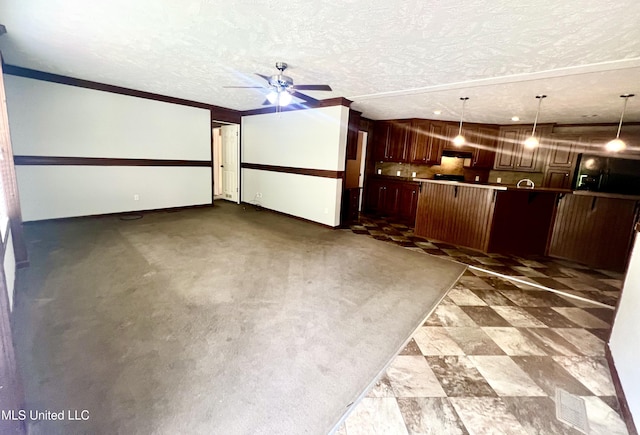 interior space featuring a textured ceiling, a ceiling fan, and baseboards
