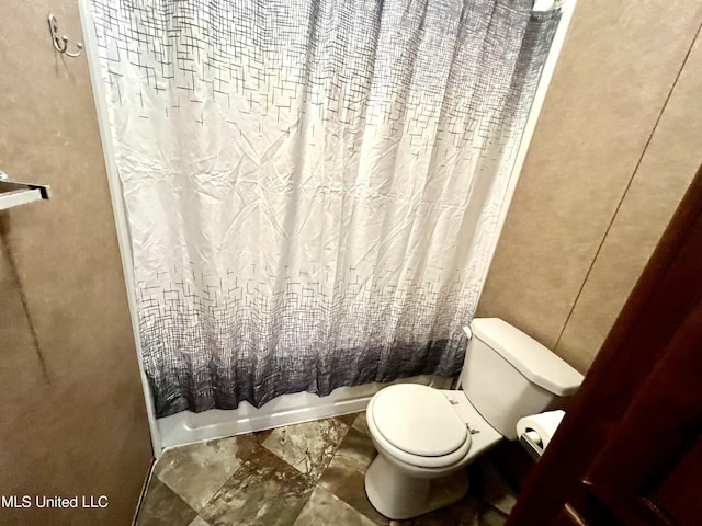 bathroom with toilet and shower / bath combo with shower curtain