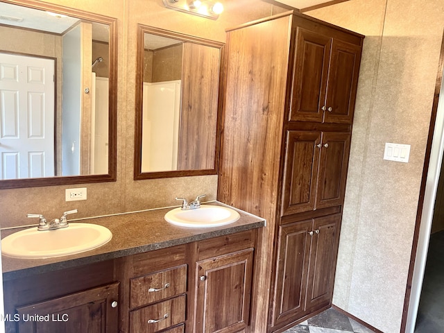 full bathroom featuring double vanity and a sink