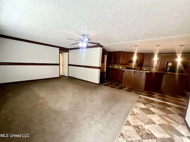 unfurnished living room featuring crown molding, a ceiling fan, a textured ceiling, and baseboards