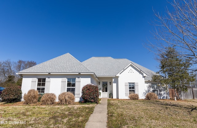 view of front facade featuring a front lawn and roof with shingles