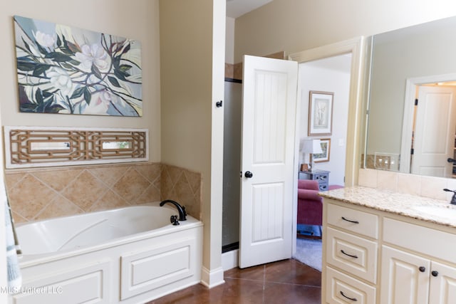 full bathroom with a garden tub, vanity, and tile patterned floors