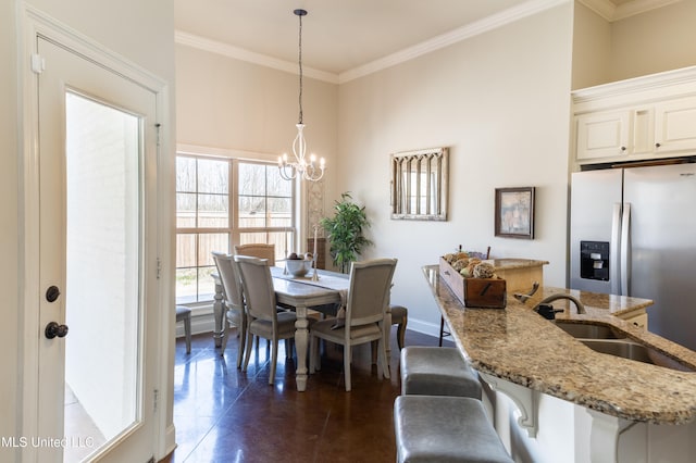 dining room with ornamental molding, a notable chandelier, and baseboards