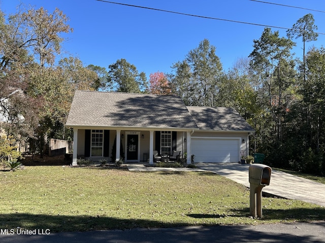 view of front of home featuring covered porch, a garage, and a front lawn