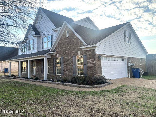 view of front of property featuring a garage, a front yard, and covered porch