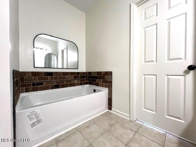 bathroom featuring tile patterned floors and a tub