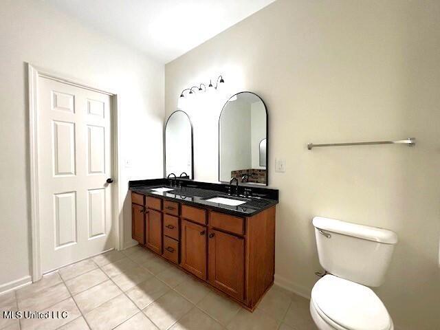 bathroom with vanity, tile patterned floors, and toilet