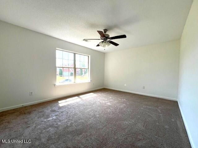 spare room with dark carpet, a textured ceiling, and ceiling fan