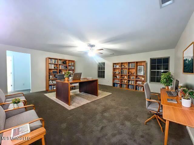 carpeted office featuring ceiling fan