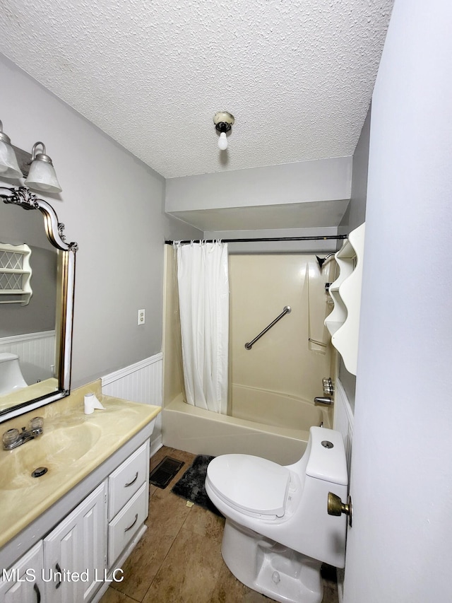98 Danny Ln, Sardis, MS 38666 - bathroom with vanity, toilet, wainscoting, shower / tub combo with curtain, and a textured ceiling