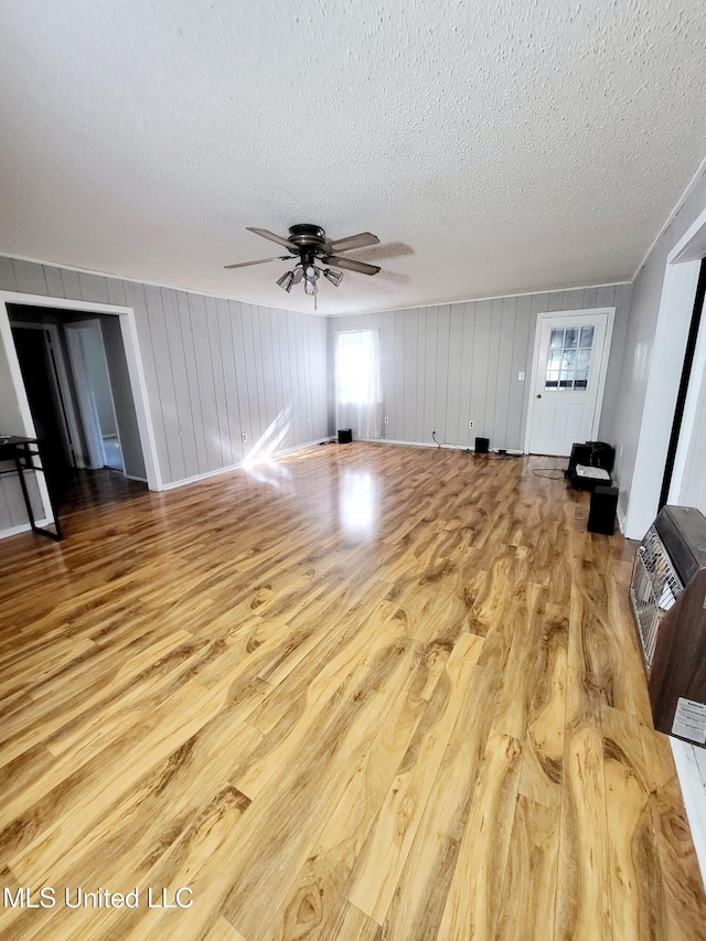98 Danny Ln, Sardis, MS 38666 - unfurnished living room with a textured ceiling, heating unit, wood finished floors, and ceiling fan