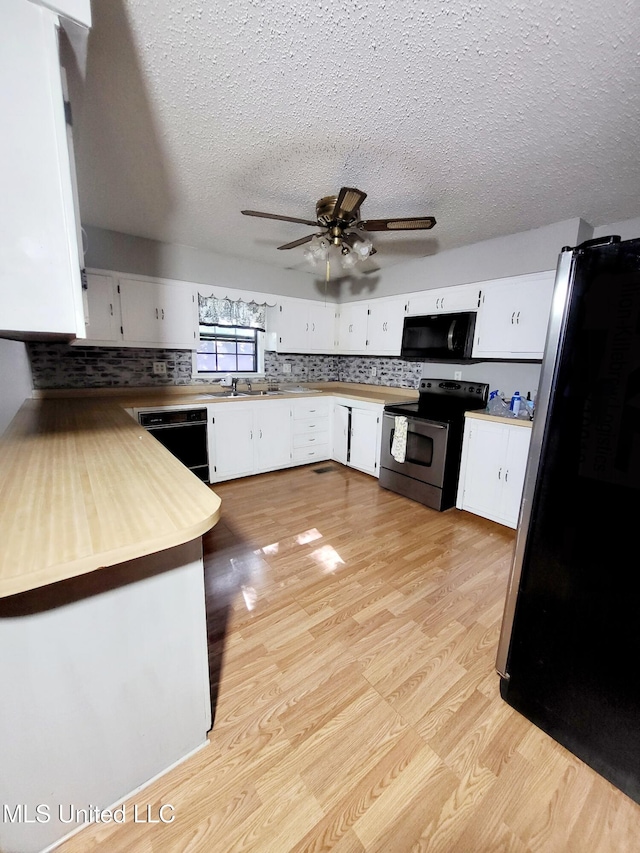 98 Danny Ln, Sardis, MS 38666 - kitchen with black appliances, light wood-style flooring, white cabinets, a textured ceiling, and a ceiling fan