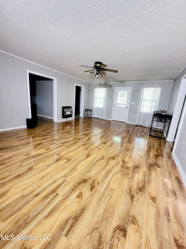 98 Danny Ln, Sardis, MS 38666 - unfurnished living room featuring wood finished floors, a textured ceiling, heating unit, and a ceiling fan