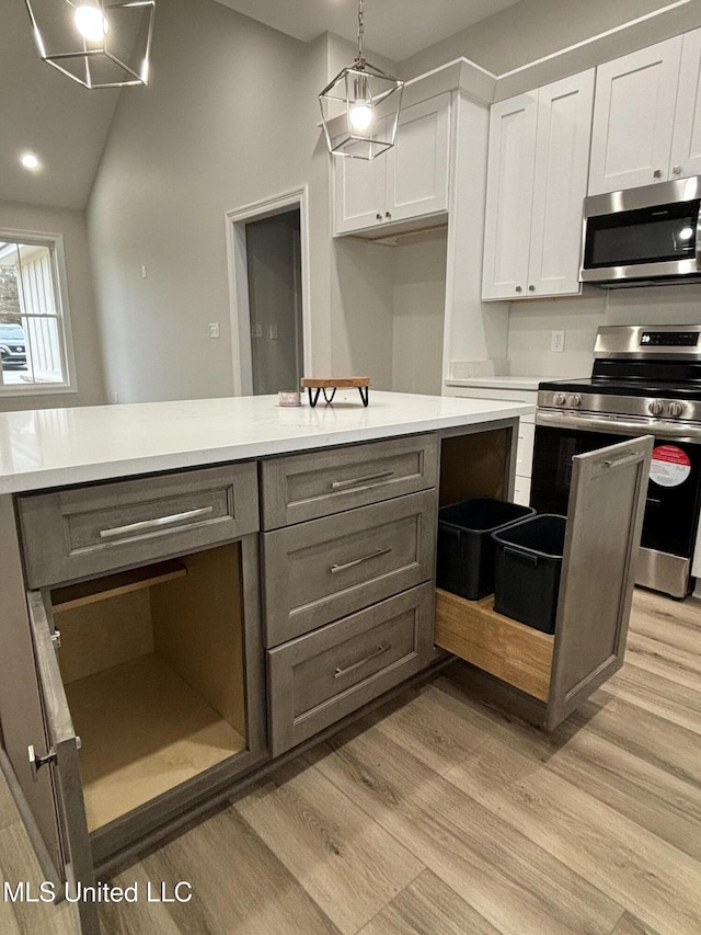 kitchen with gray cabinets, white cabinets, hanging light fixtures, light hardwood / wood-style floors, and stainless steel appliances