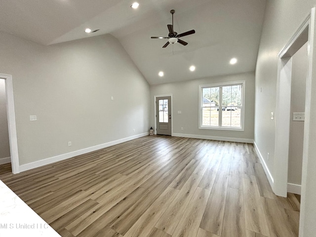 unfurnished living room with high vaulted ceiling, light hardwood / wood-style floors, and ceiling fan