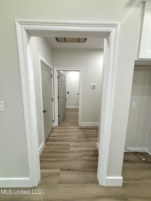 corridor with light hardwood / wood-style flooring