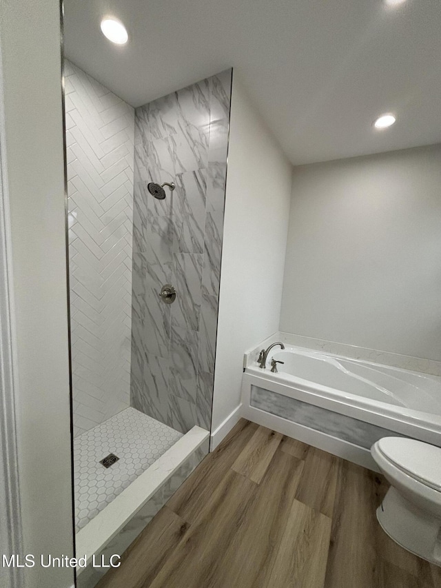 bathroom featuring wood-type flooring, toilet, and plus walk in shower