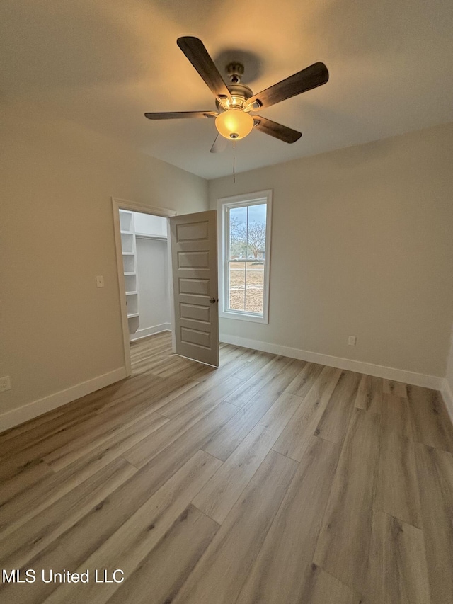 spare room with ceiling fan and light wood-type flooring