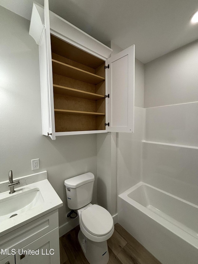 full bathroom with hardwood / wood-style flooring, vanity, shower / bathtub combination, and toilet