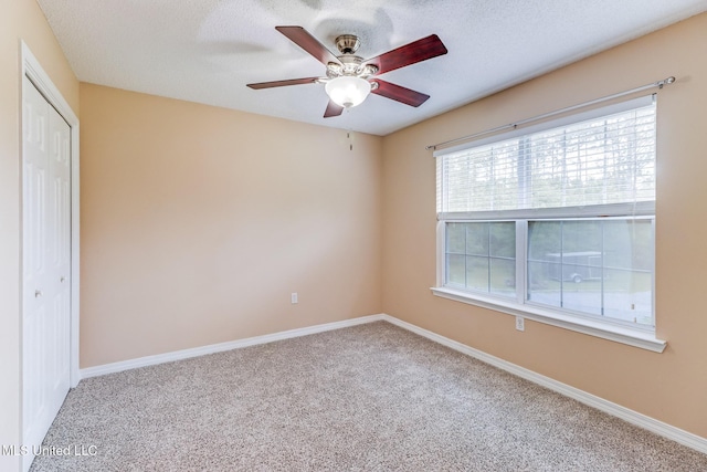 spare room with carpet flooring, baseboards, and ceiling fan