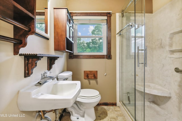 bathroom with walk in shower, toilet, and sink