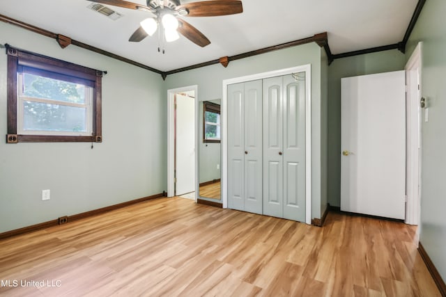 unfurnished bedroom featuring ornamental molding, a closet, ceiling fan, and light wood-type flooring