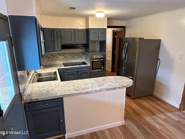 kitchen with stainless steel appliances, kitchen peninsula, sink, and light wood-type flooring