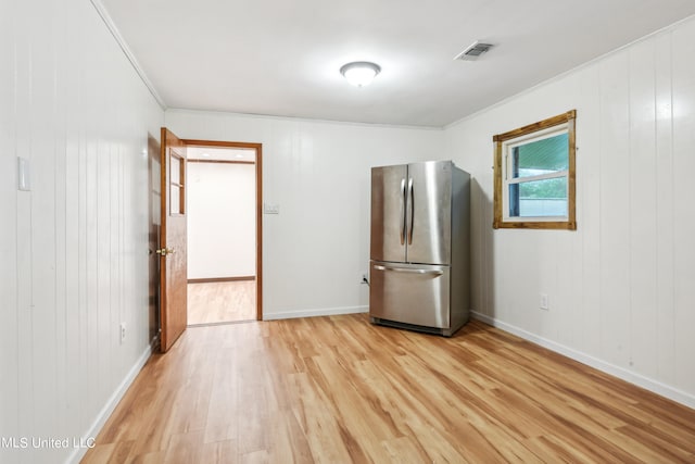 spare room with ornamental molding and light hardwood / wood-style floors