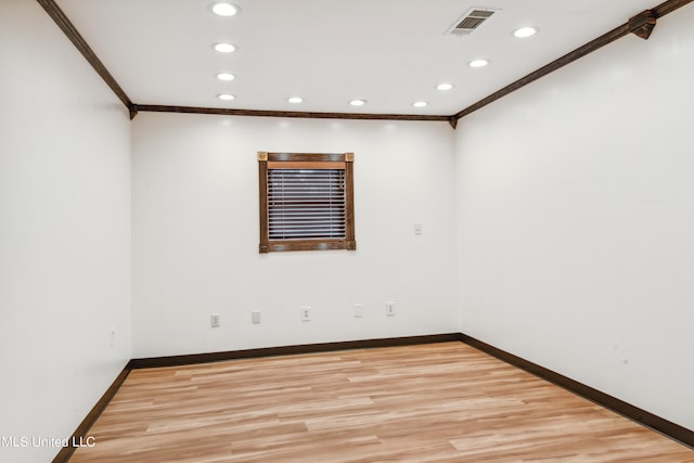 unfurnished room featuring crown molding and light wood-type flooring