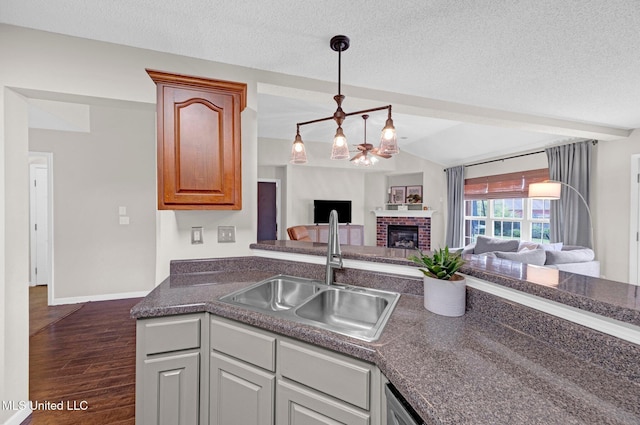 13245 Braybourne Pkwy, Olive Branch, MS 38654 - kitchen featuring a sink, open floor plan, dark countertops, dark wood finished floors, and a fireplace