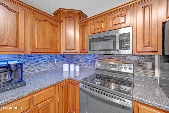 13245 Braybourne Pkwy, Olive Branch, MS 38654 - kitchen featuring stainless steel appliances, brown cabinetry, and tasteful backsplash