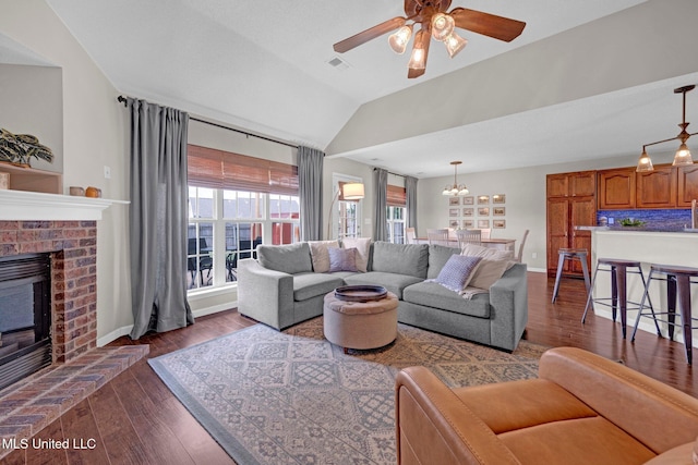 13245 Braybourne Pkwy, Olive Branch, MS 38654 - living area with dark wood-style floors, a fireplace, a ceiling fan, vaulted ceiling, and baseboards