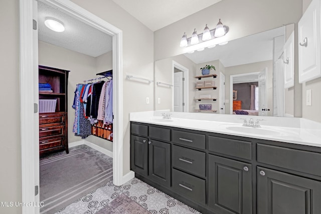 13245 Braybourne Pkwy, Olive Branch, MS 38654 - bathroom with double vanity, a spacious closet, and baseboards