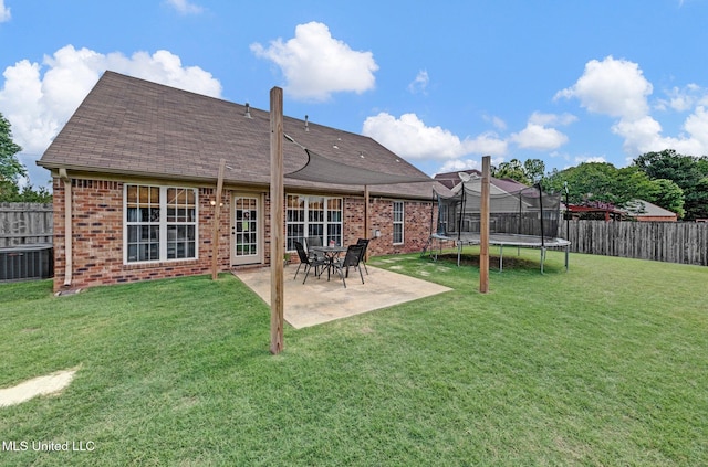 13245 Braybourne Pkwy, Olive Branch, MS 38654 - back of house with a trampoline, brick siding, central air condition unit, a patio area, and a shingled roof