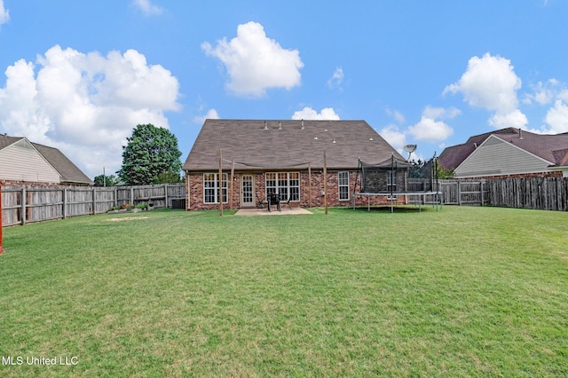 13245 Braybourne Pkwy, Olive Branch, MS 38654 - back of property featuring a trampoline, brick siding, and a patio