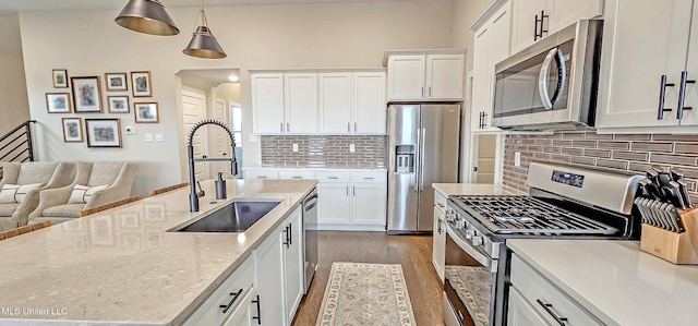 13453 Birch Bnd, Olive Branch, MS 38654 - kitchen with appliances with stainless steel finishes, a sink, dark wood finished floors, backsplash, and white cabinets
