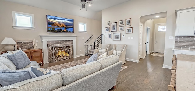 13453 Birch Bnd, Olive Branch, MS 38654 - living room featuring a ceiling fan, dark wood-style flooring, a brick fireplace, and baseboards