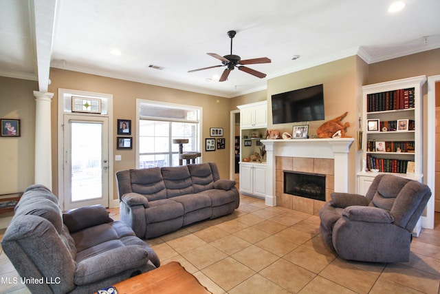 tiled living room featuring ornamental molding, a tile fireplace, and ceiling fan