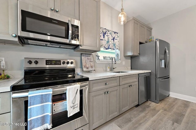 208 Sycamore St, Bay Saint Louis, MS 39520 - kitchen with appliances with stainless steel finishes, gray cabinets, light wood-style floors, and light countertops