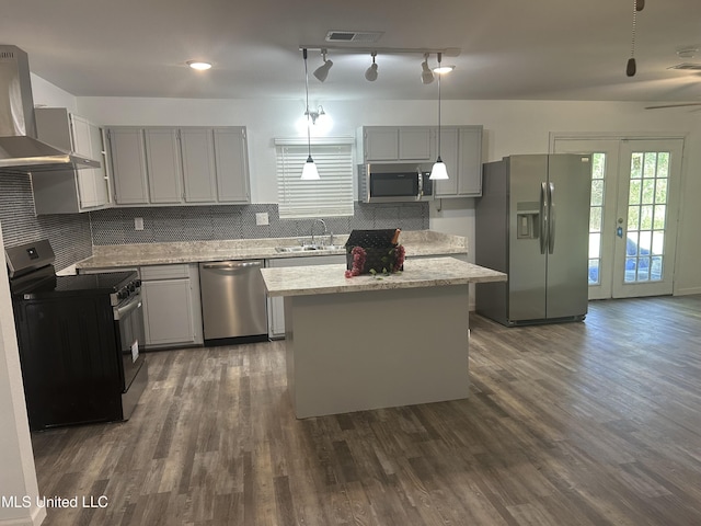 5736 Eastwood Dr, Moss Point, MS 39563 - kitchen with stainless steel appliances, wall chimney exhaust hood, decorative backsplash, gray cabinetry, and dark wood-style flooring
